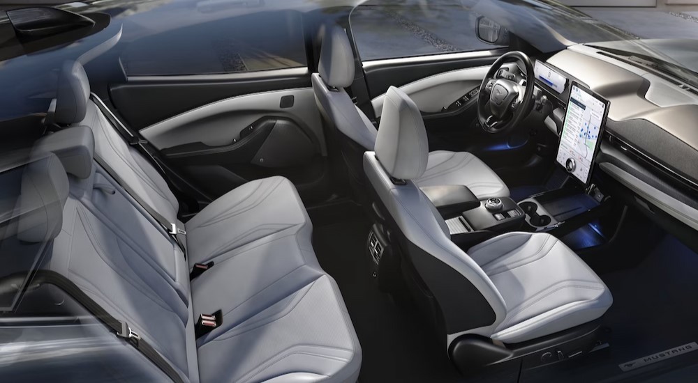 The black and gray interior and dash of a 2024 Ford Mustang Mach-E is shown.