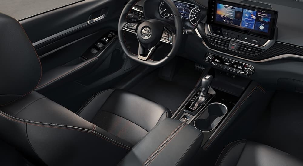 The black interior and dash of a 2024 Nissan Altima is shown.