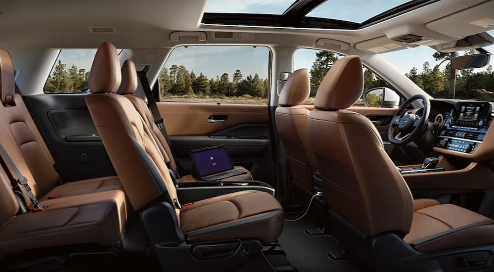 The black and brown interior and dash of a 2024 Nissan Pathfinder is shown.