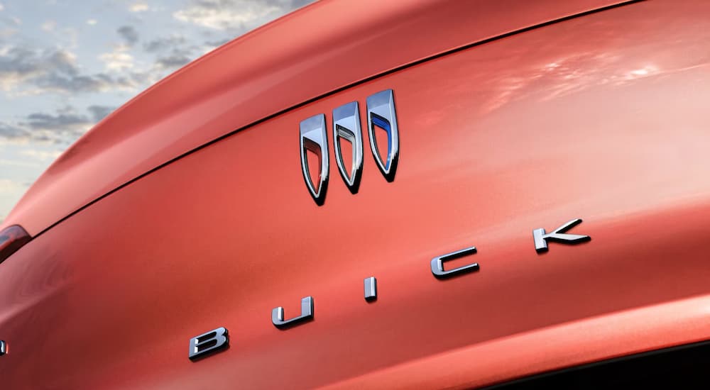 A close up of the rear badge on an orange 2024 Buick Envista is shown.