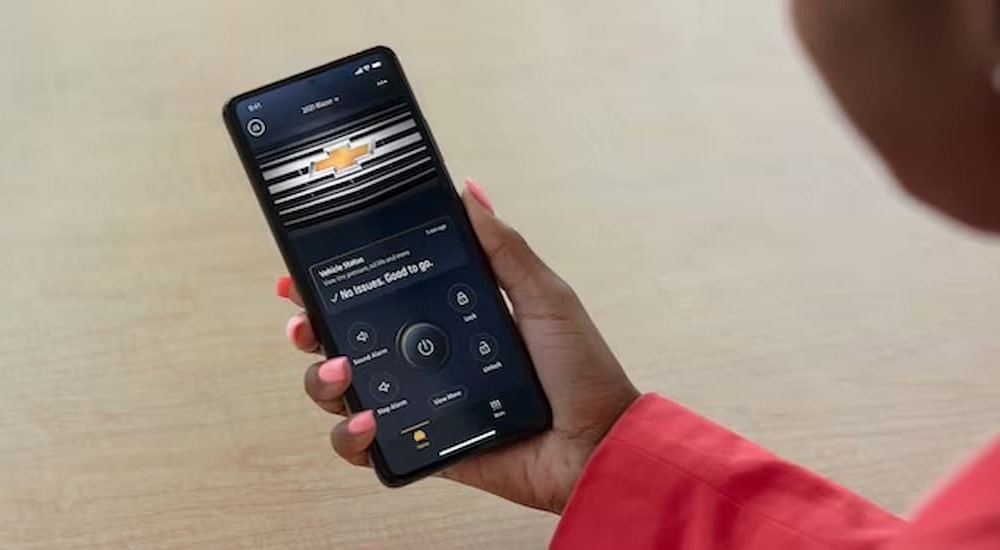 A person is shown using the myChevrolet mobile app on their phone.