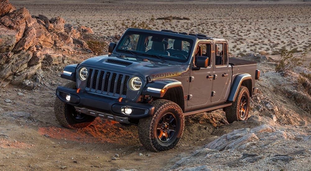 A black 2021 Jeep Gladiator Mojave is shown off-roading in a desert.