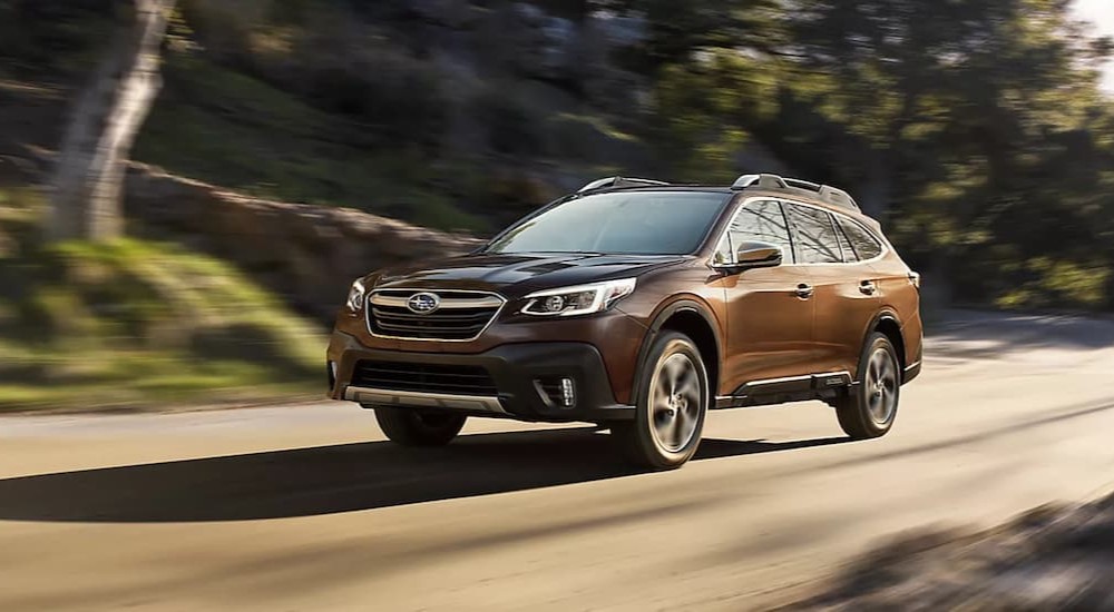 A brown 2022 Subaru Outback Touring is shown driving on a road.