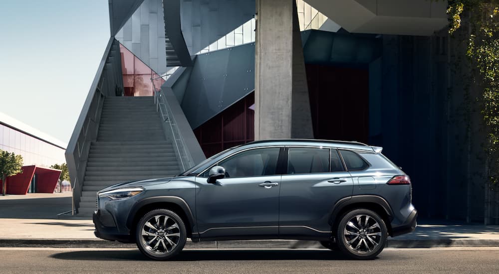 A blue 2022 Toyota Corolla Cross is shown parked near stairs after visiting a used car dealership.