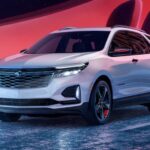 A white 2024 Chevy Equinox LT for sale is shown driving on a bridge.