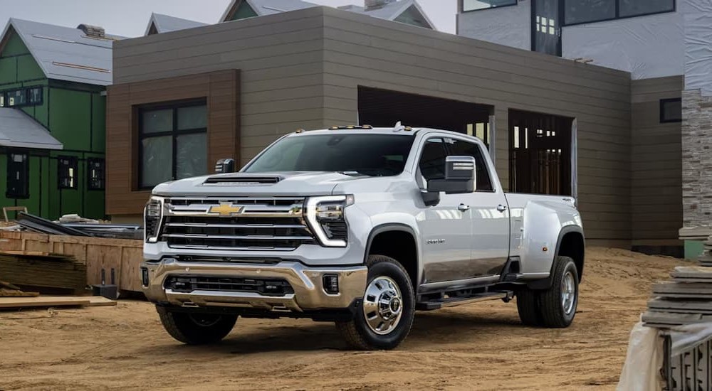 A white 2023 Chevy Silverado 3500HD is shown parked on a construction site.