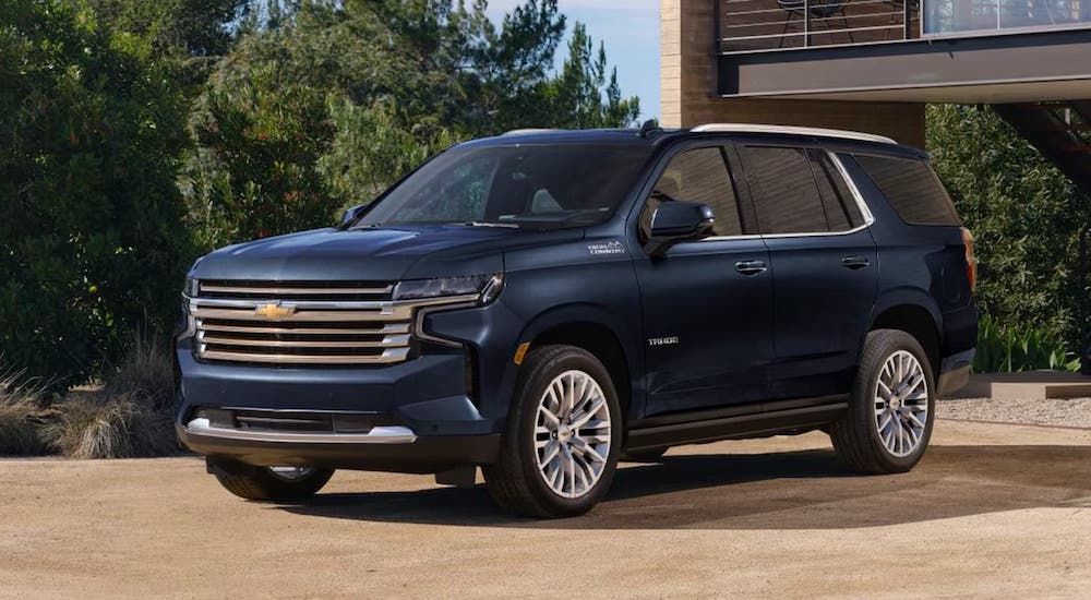 One of the more popular used SUVs for sale, a blue 2023 Chevy Tahoe, is shown parked in a driveway.