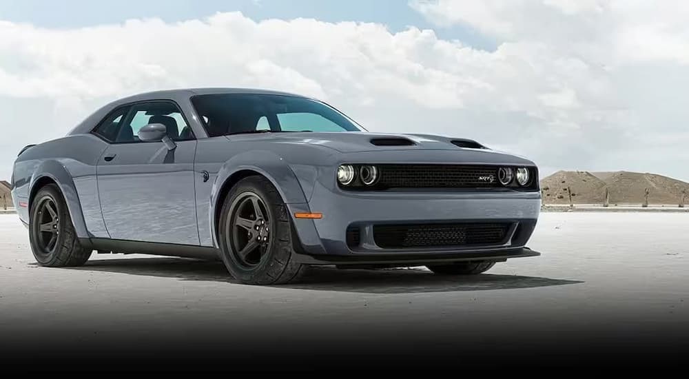 A gray 2023 Dodge Challenger SRT is shown parked on sand.