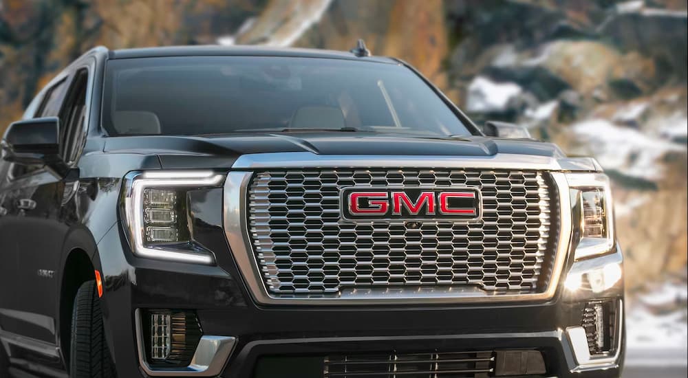 A close-up on the grille of a black 2023 GMC Yukon Denali is shown.