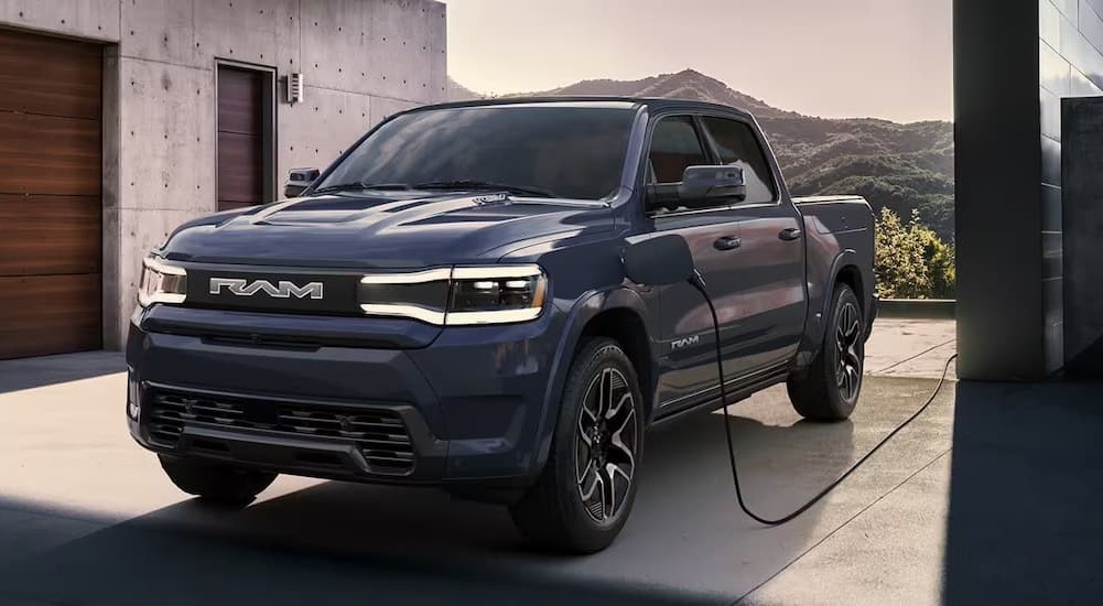 A dark blue 2023 Ram 1500 EV is shown charging.