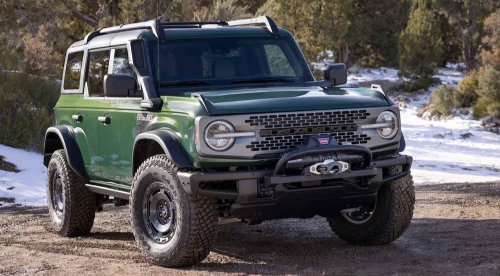 A green 2024 Ford Bronco Everglades is shown parked off-road near snow.