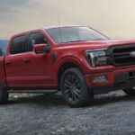 A red 2024 Ford F-150 Lariat is shown parked off-road after winning the 2024 Ford F-150 vs 2024 Chevy Silverado 1500 competition.