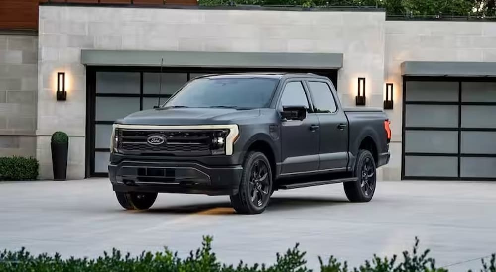 A gray 2024 Ford F-150 Lightning is shown parked on a driveway near a Ford F-150 Lightning dealer.