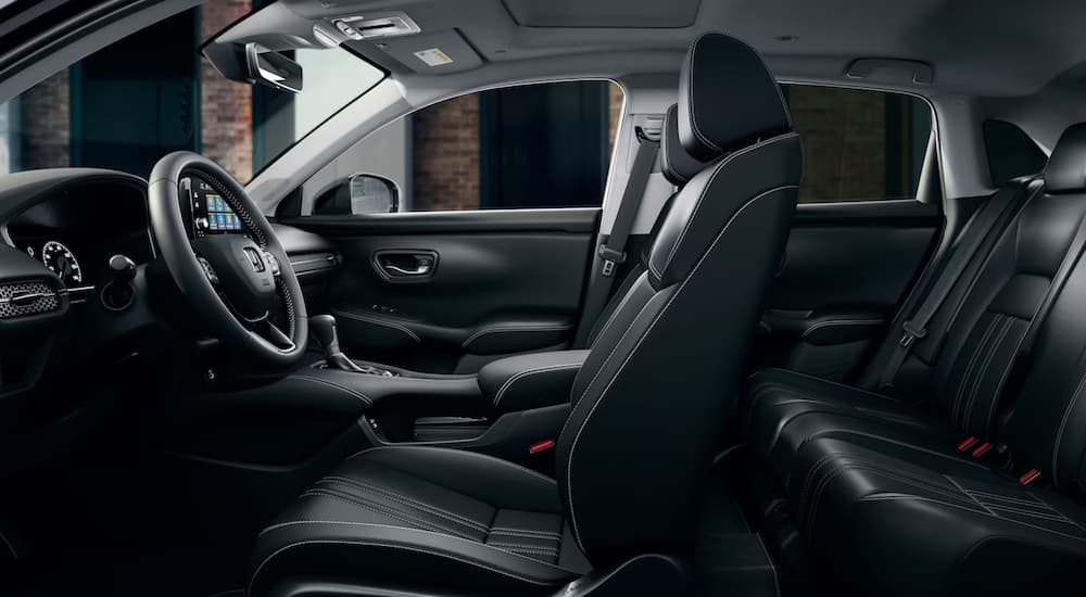 The black interior and dash of a 2024 Honda HR-V is shown from a side view.