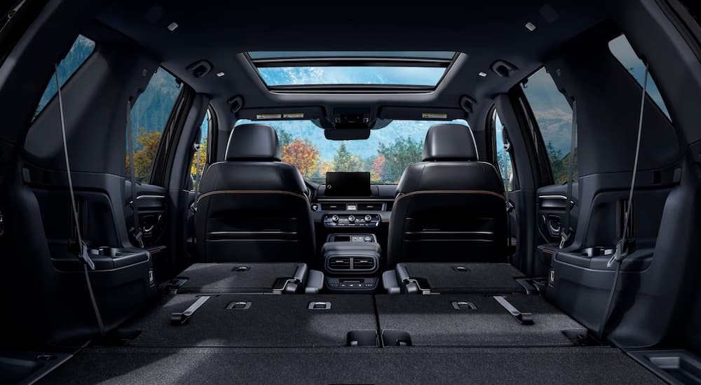 The black interior of a 2024 Honda Pilot is shown from the rear.