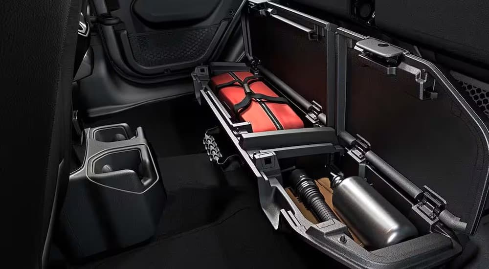 A storage compartment in the interior of a 2024 Jeep Gladiator Rubicon is shown.