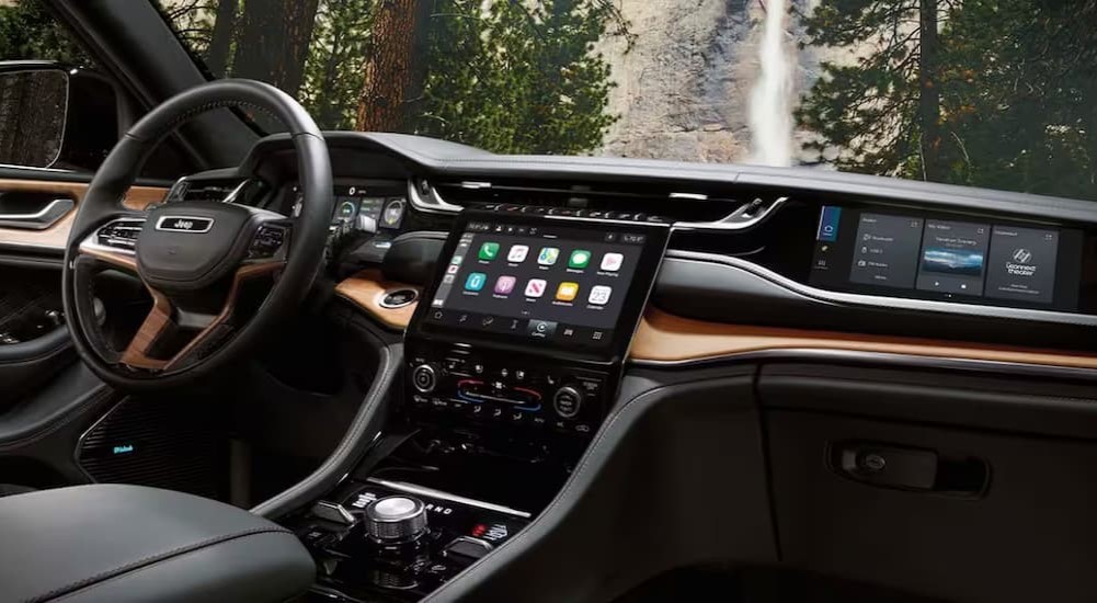 The black and brown interior and dash of a 2024 Jeep Grand Cherokee is shown.