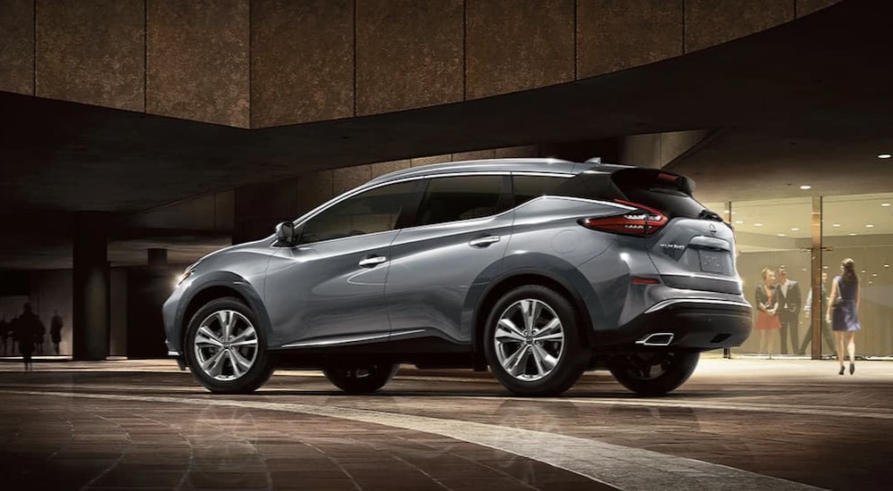 A silver 2024 Nissan Murano is shown parked near people.