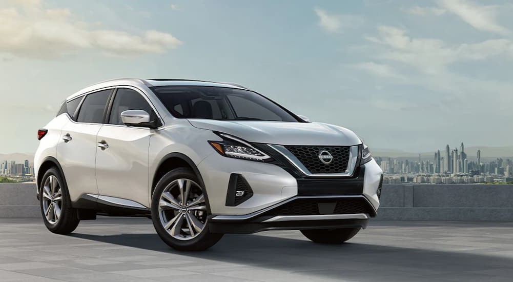 A white 2024 Nissan Murano is shown parked near a city.