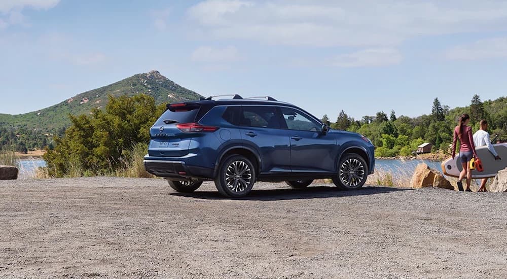 A blue 2024 Nissan Rogue is shown parked.