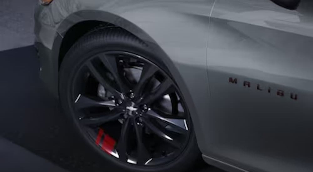 The close-up of a wheel on a gray 2024 Chevy Malibu is shown.