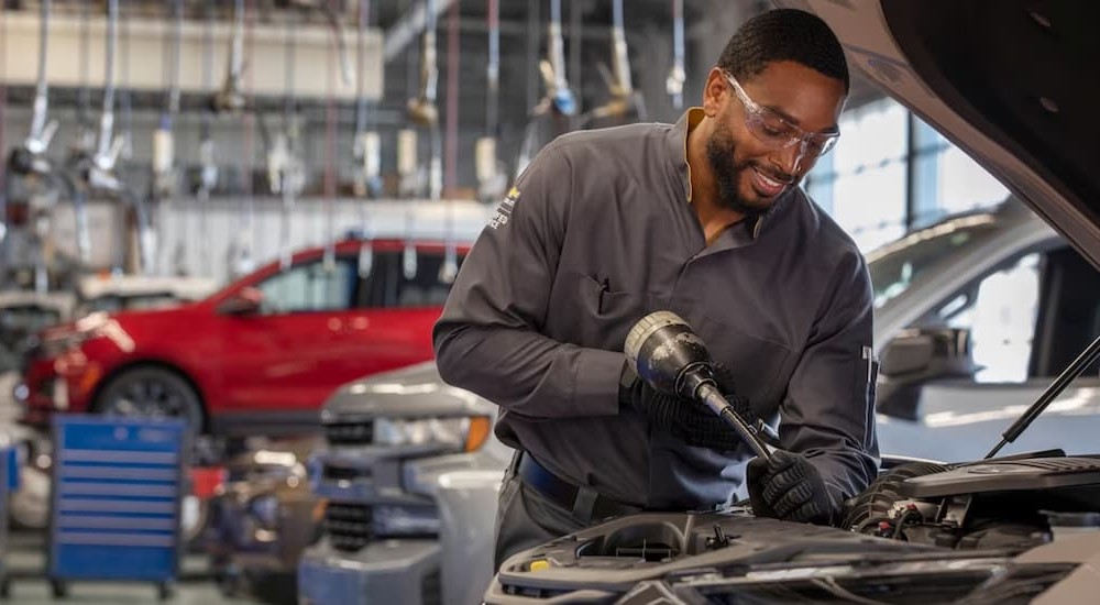 A mechanic is shown working on a vehicle.