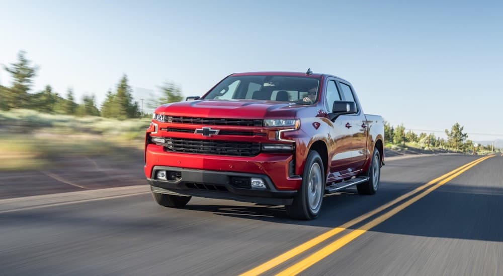 A red 2020 Chevy silverado 1500 is shown driving on a highway.