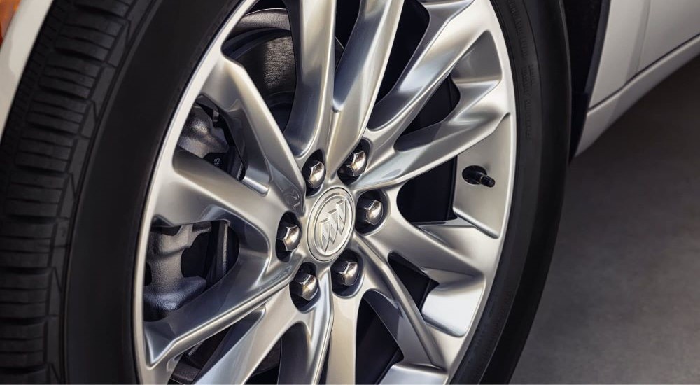 A close-up on the wheel of a 2023 Buick Enclave Avenir is shown.