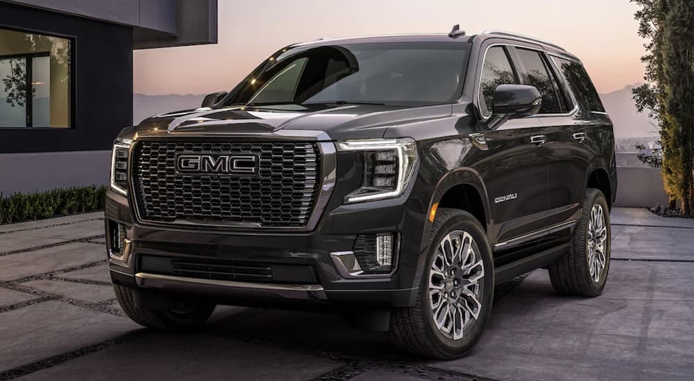 A popular GMC Yukon XL for sale, a black 2023 GMC Yukon XL Denali Ultimate, is shown parked near a building.