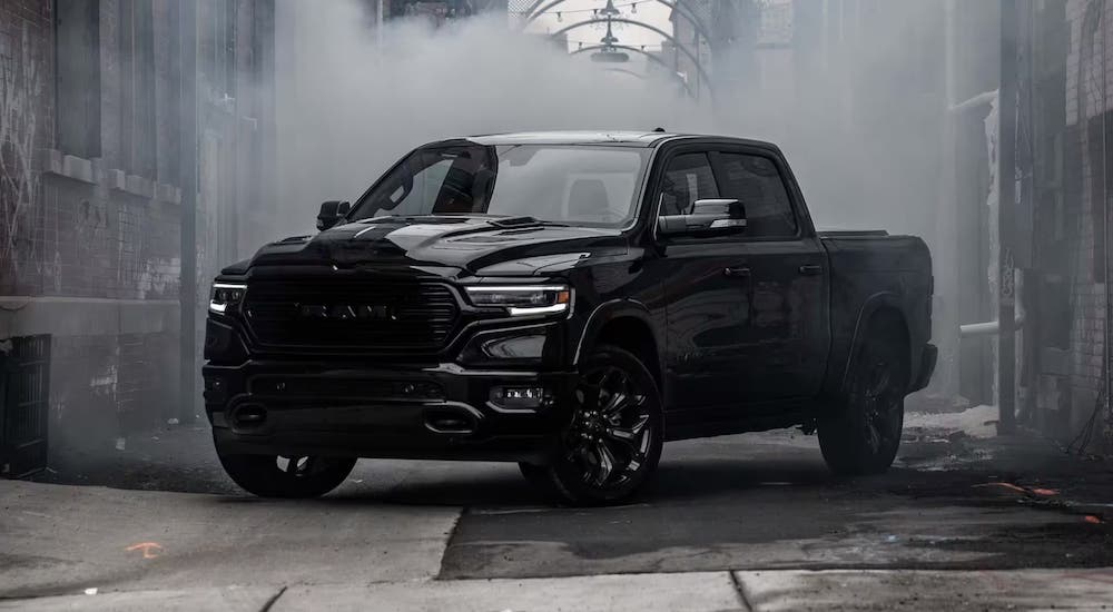 A black 2023 Ram 1500 is shown parked in a city.