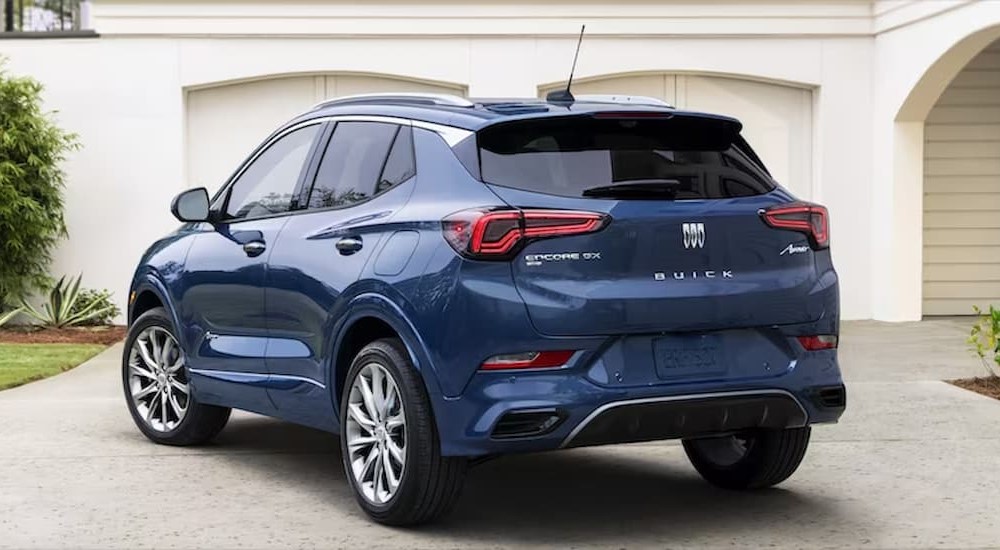 A blue 2024 Buick Encore GX is shown parked near a garage.