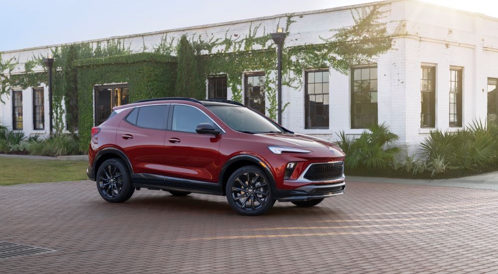 A red 2024 Buick Encore GX ST is shown parked outside a building after visiting a Buick dealer.