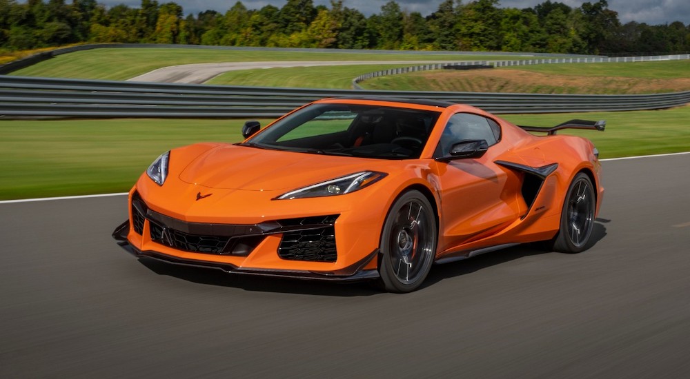 An orange 2024 Chevy Corvette Z06 is shown driving on a track.