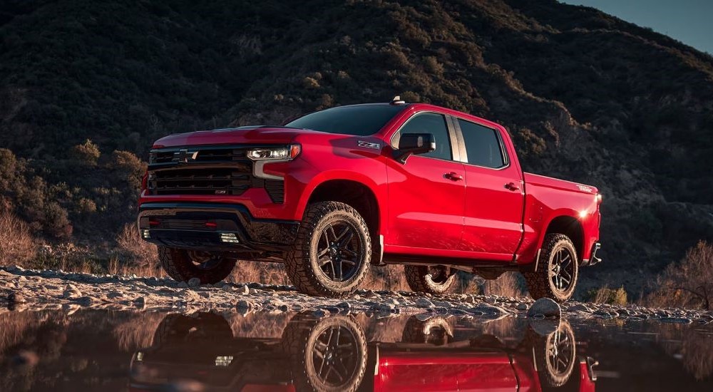 A red 2024 Chevy Silverado 1500 Z71 Trail Boss is shown parked off-road.