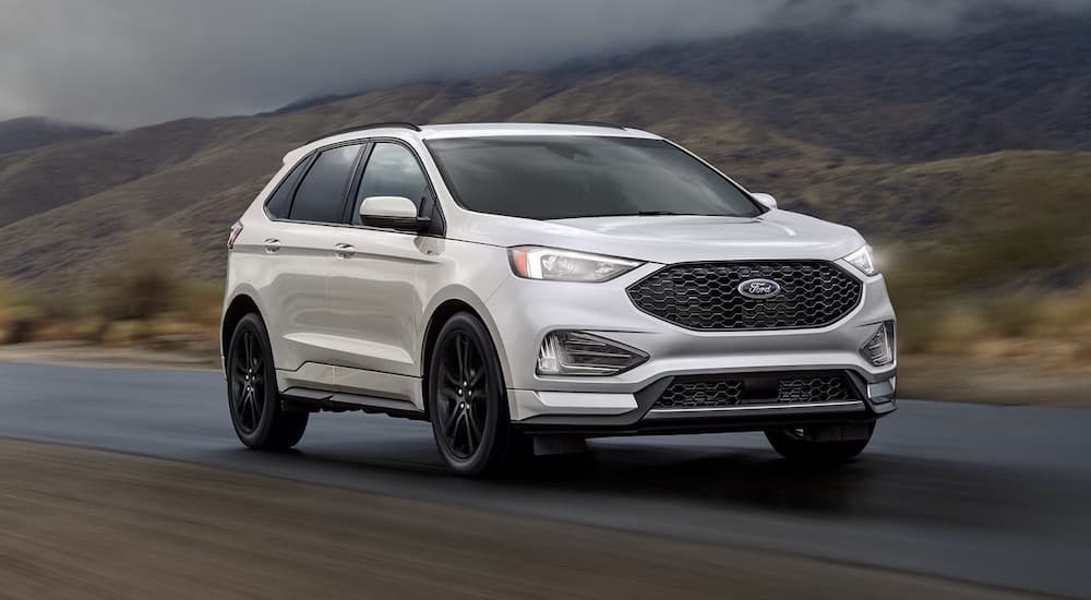 A white 2024 Ford Edge ST Line is shown driving.