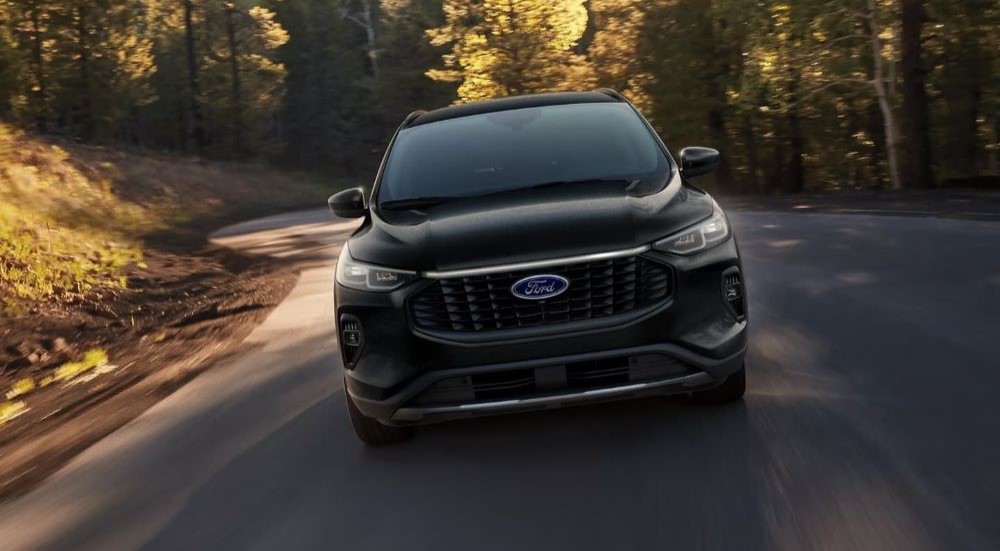 A black 2024 Ford Escape is shown driving.