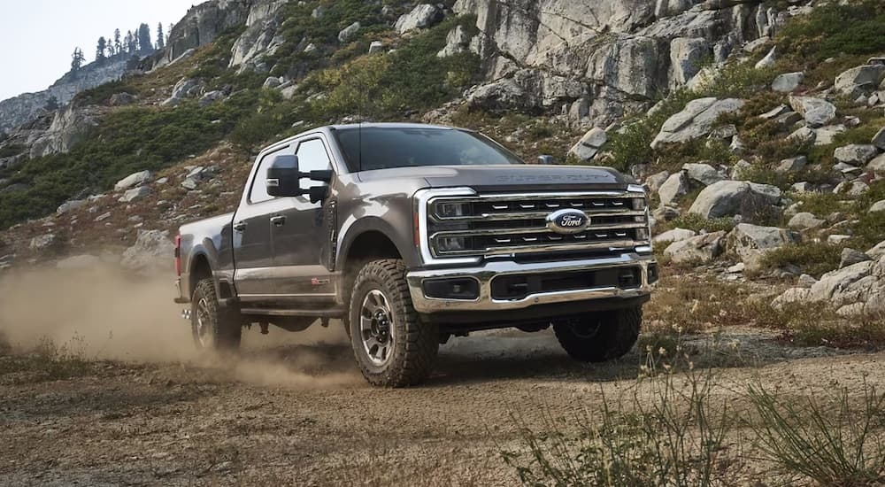 A grey 2024 Ford F-250 Tremor is shown driving off-road.