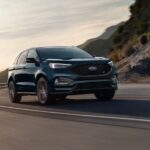 A green 2024 Ford Edge is shown driving on a highway.