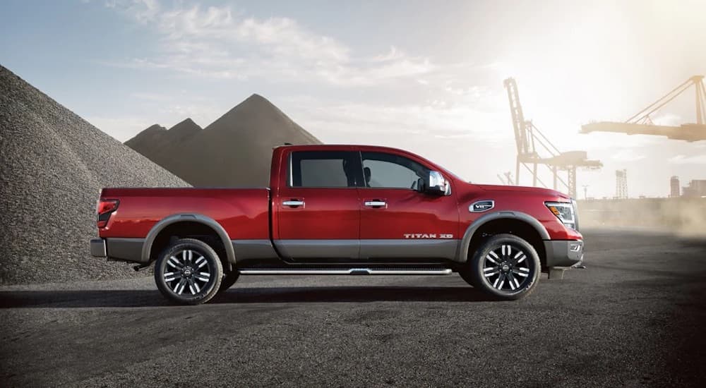 A red 2024 Nissan Titan XD is shown from the side.