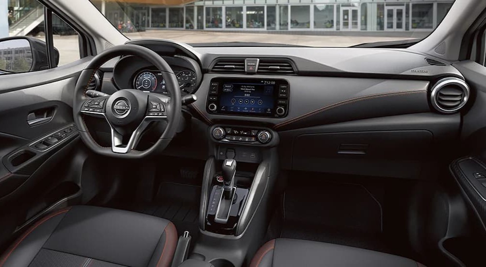 The black interior and dash of a 2024 Nissan Versa is shown.