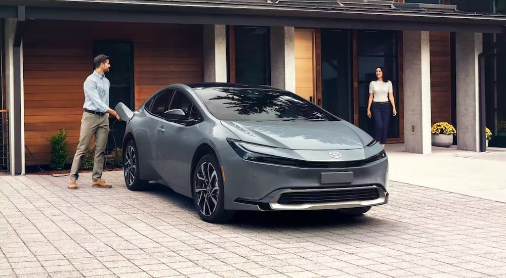 A 2024 Toyota Prius Prime is shown charging on a driveway.