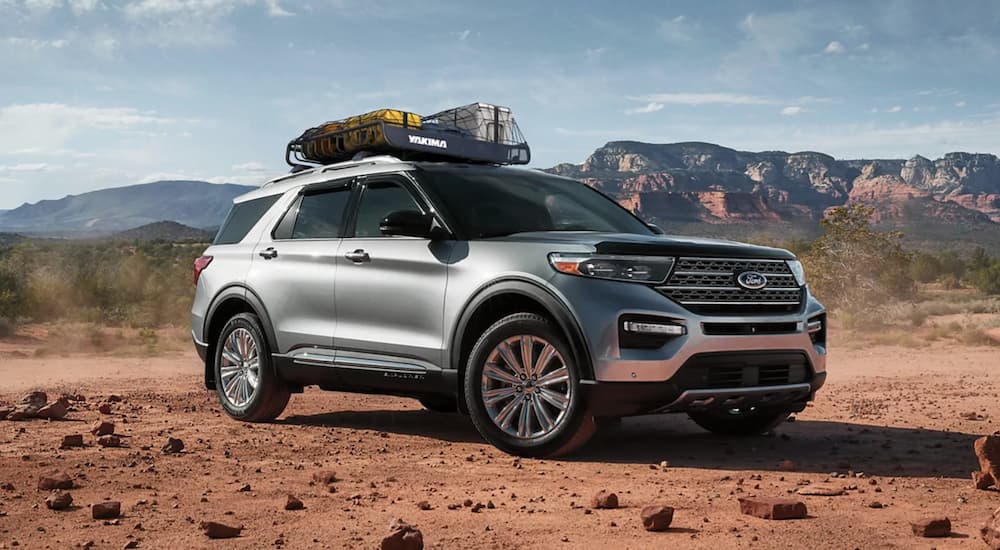 One of many CPO Fords for sale, a silver 2021 Ford Explorer, is shown parked off-road.