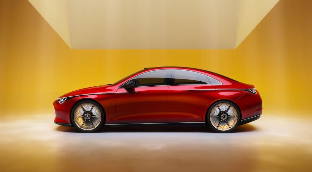 A red 2023 Mercedes-Benz Concept CLA-Class is shown parked in a yellow room.