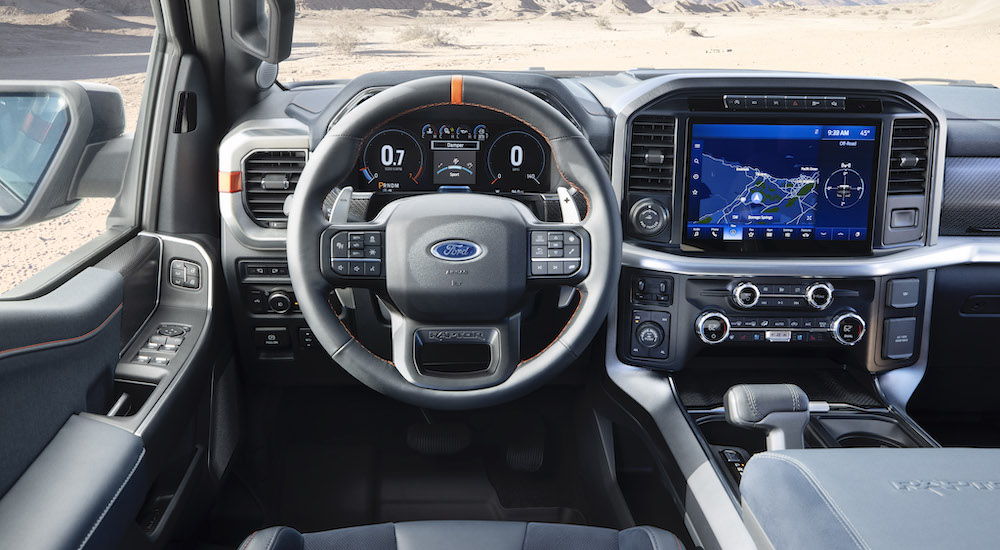 The steering wheel and infotainment center in a 2021 Ford F-150 Raptor.