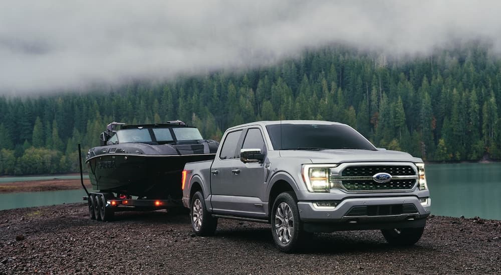 A silver 2023 Ford Lobo from Mexico towing a speed boat out of the water.