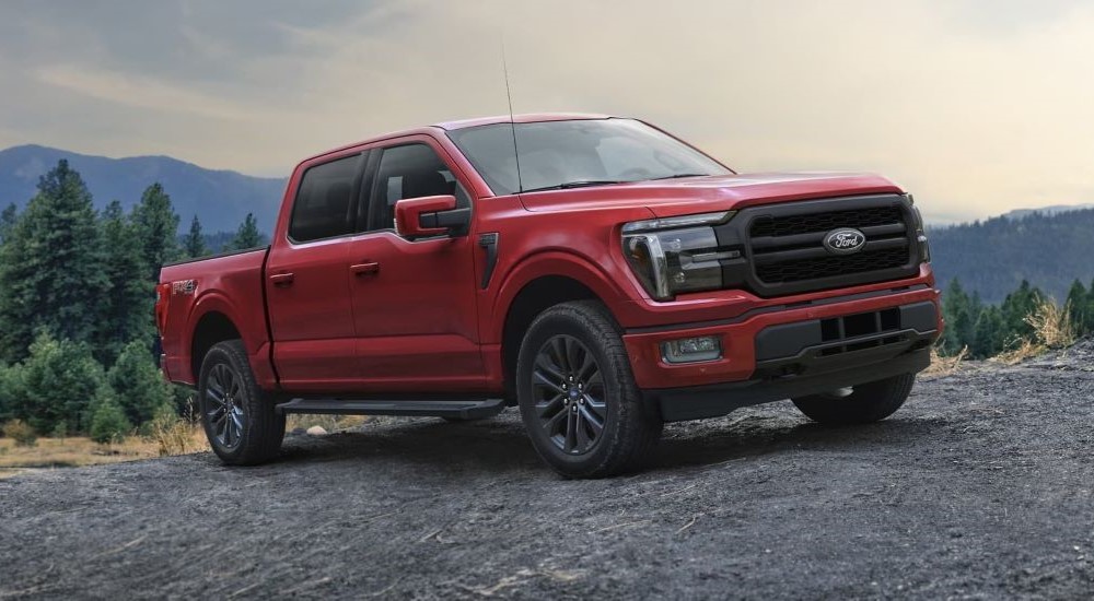 A red 2024 Ford F-150 Lariat parked in the mountains.