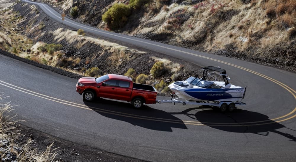 A red 2020 Ford Ranger is shown towing a boat.