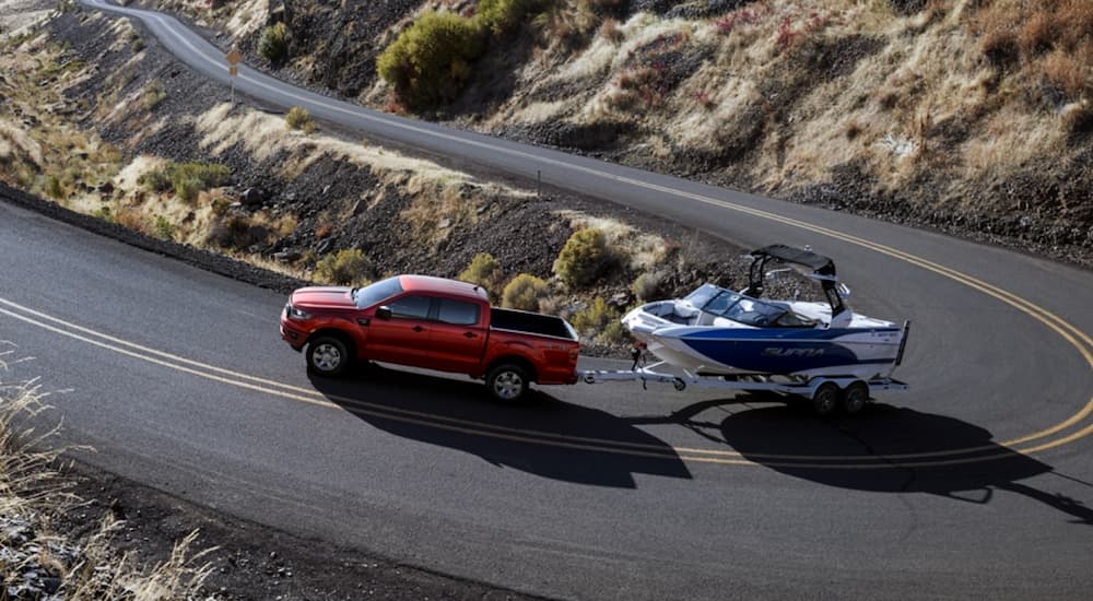 A red 2020 Ford Ranger is shown towing a boat.