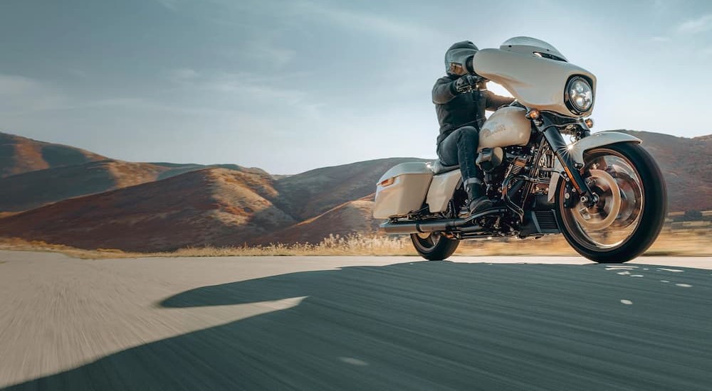 A white 2023 Harley-Davidson Street Glide ST is shown driving on a highway.