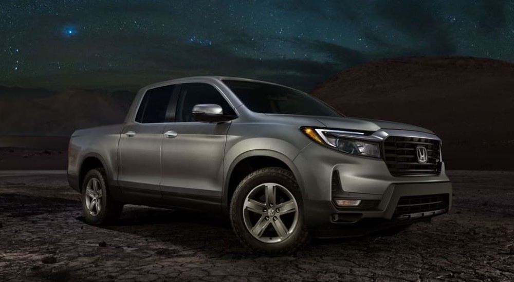 A silver 2023 Honda Ridgeline RTL-E is shown parked off-road.